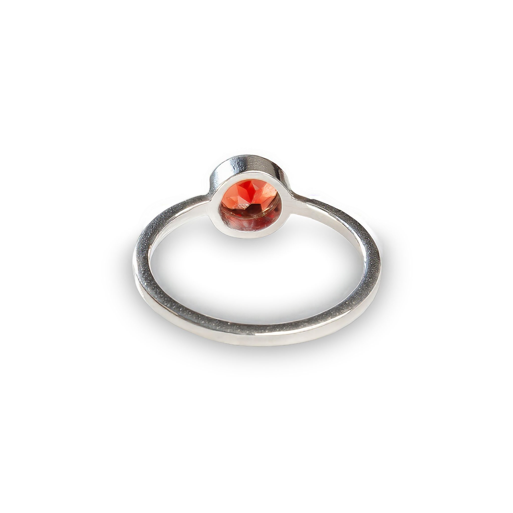 Minimalist sterling silver ring with a bezel-set round deep red garnet gemstone. A timeless and elegant design inspired by Nordic simplicity, crafted to celebrate natural beauty and imperfection.